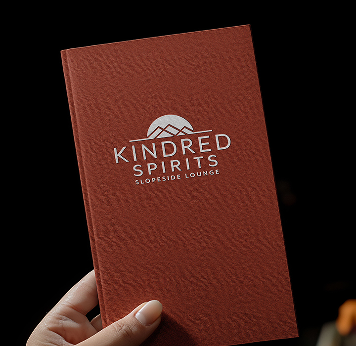 Kindred Spirits Slopeslide Lounge Logo on menu book